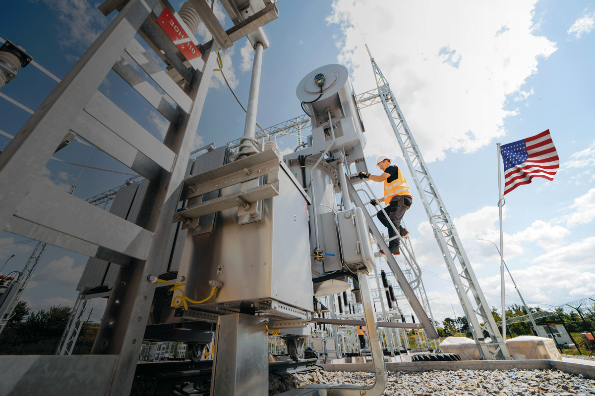 Worker in safety gear climbing ladder to access electrical equipment at outdoor power site.