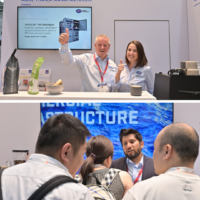 JST Power Equipment staff interacting with attendees and showcasing switchgear products at their Europe Tradefair booth JST Power staff greet visitors and discuss products at their Europe Tradefair booth with display screens and branded materials.