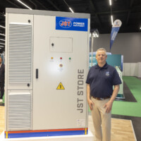 F Kell, a JST Power team member next to a Battery Energy Storage System display at Ennovation 2025 at Messezentrum Salzburg in Austria JST Power team member next to Battery Energy Storage System cabinet