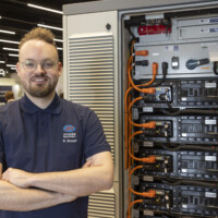 R. Bouyer from JST Power Equipment team with s Battery Energy Storage System (BESS) cabinet at Ennovation 2025 in Messezentrum Salzburg JST Power Equipment team with Battery Energy Storage System (BESS) cabinet