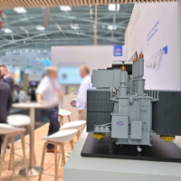 A detailed unit substation model displayed by JST Power Equipment at a trade show, highlighting transformer technology and design Unit substation model on display at a trade show booth.