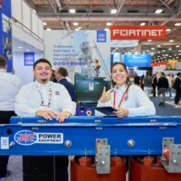 JST Power Equipment team at DISTRIBUTECH 2025 booth with electrical equipment and signage in view