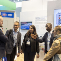 Visitors engage in a lively exchange at the JST Power Equipment booth, Smarter E Europe 2025, Messezentrum München. Group of attendees in discussion at the JST Power Equipment booth during Smarter E Europe 2025 in Germany.