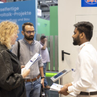 JST Power connects with industry professionals at The Smarter E Europe 2025, presenting cutting-edge photovoltaic and energy storage technology. JST Power Equipment team member discussing energy storage solutions with two attendees at The Smarter E Europe 2025 booth.