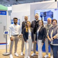 The JST Power team showcasing their Battery Energy Storage System (BESS) at The Smarter E Europe 2025, highlighting innovation in sustainable energy solutions. JST Power team poses in front of their exhibition booth at The Smarter E Europe 2025, with a Battery Energy Storage System displayed behind them.