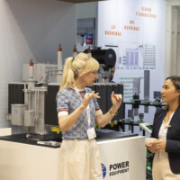 Engaged discussion at JST Power Equipment’s booth during The Smarter E Europe 2025 in München, highlighting advanced transformer solutions. Two women discussing JST Power Equipment's transformer display at The Smarter E Europe 2025 in München Messezentrum.